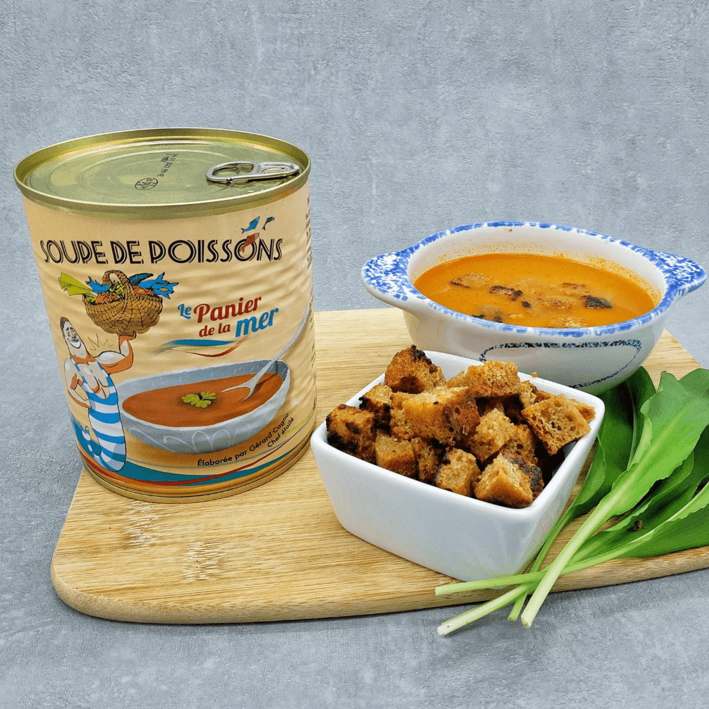 image de la boite de conserve contenant la soupe de poisson et un bol de soupe accompagné de croûtons